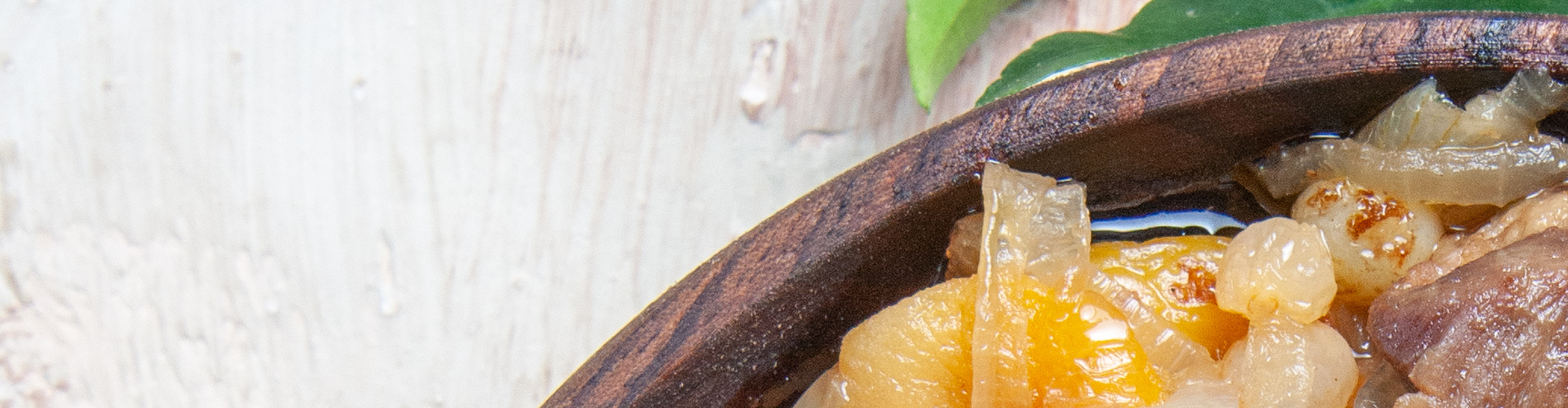 Wooden bowl with onions and chicken